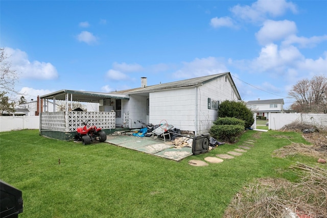 back of property featuring fence, a patio area, and a yard