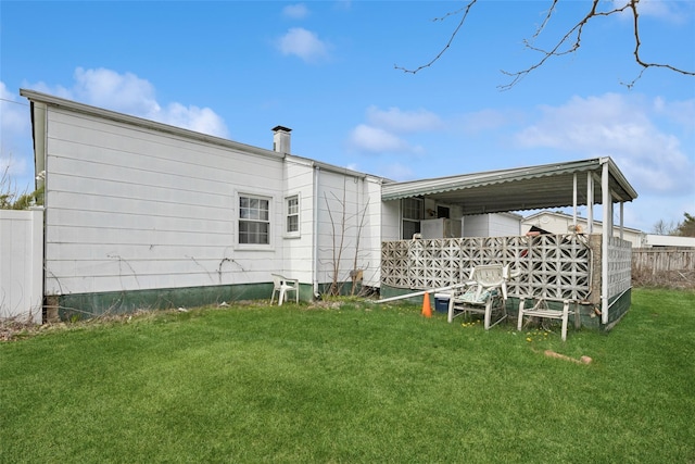back of property featuring a yard and fence
