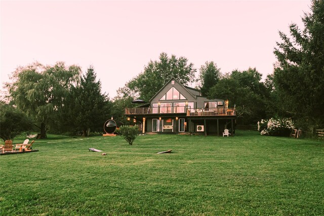 rear view of house featuring a yard and a deck