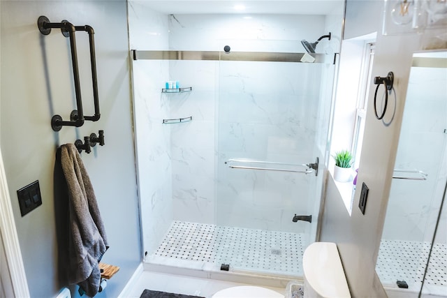 full bathroom featuring toilet and a marble finish shower