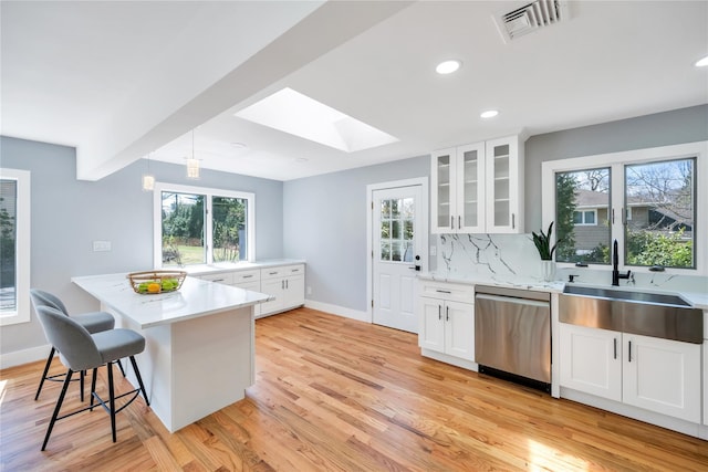 16 Huckleberry Ln, Oyster Bay, NY 11771 - kitchen featuring light countertops, a sink, baseboards, a skylight, and dishwasher