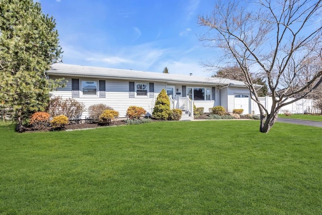 single story home with an attached garage, a front lawn, and aphalt driveway