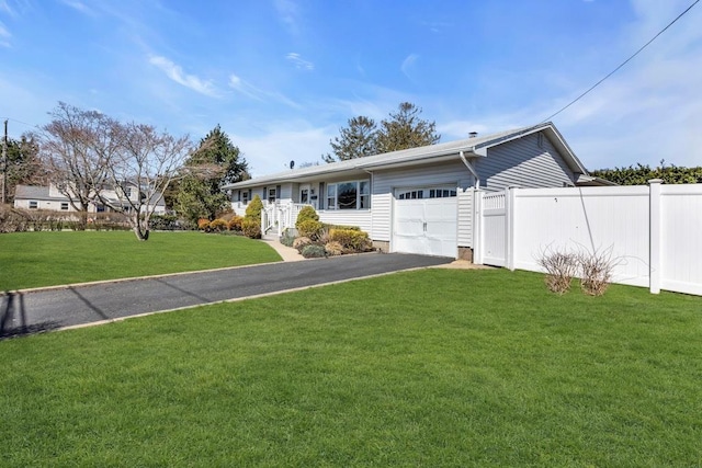 ranch-style house with a front yard, an attached garage, fence, and driveway