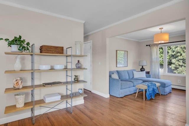 living area with baseboards, a baseboard heating unit, crown molding, and wood finished floors