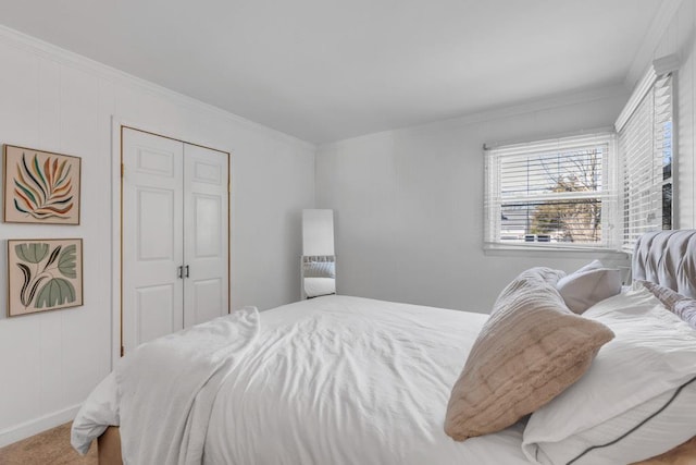 bedroom with crown molding, carpet flooring, and baseboards