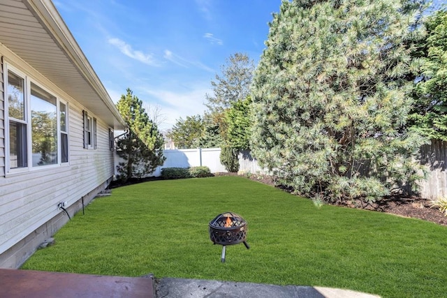 view of yard with a fenced backyard and an outdoor fire pit