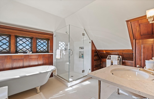 bathroom featuring a shower stall, a freestanding bath, a sink, and tile patterned flooring