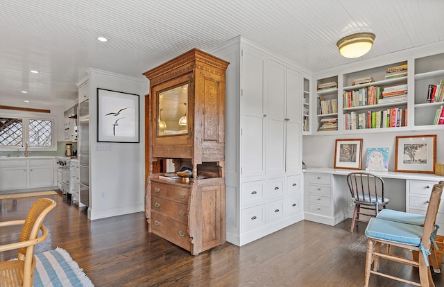 office featuring recessed lighting, built in desk, dark wood-style flooring, a sink, and baseboards