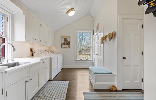clothes washing area featuring baseboards, a sink, dark wood finished floors, cabinet space, and washing machine and dryer