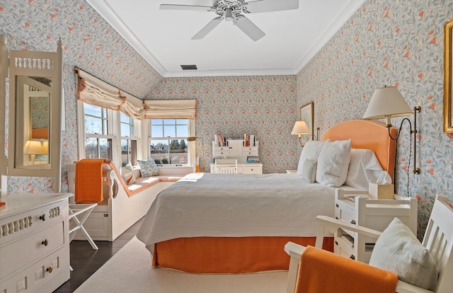 bedroom with a ceiling fan, ornamental molding, visible vents, dark wood-style flooring, and wallpapered walls