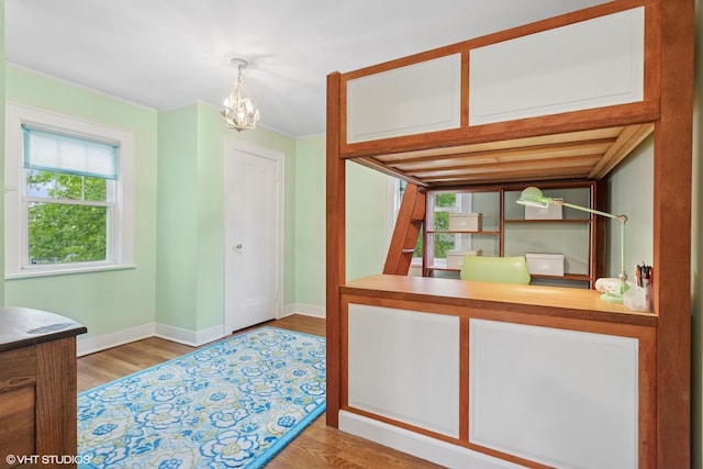 kitchen featuring a chandelier, wood finished floors, baseboards, and an office area