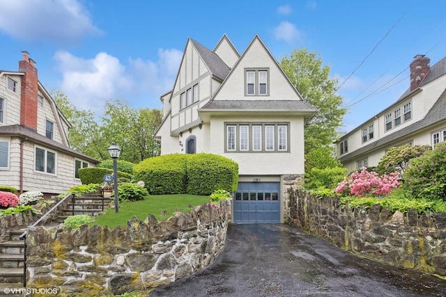 view of front facade featuring driveway, an attached garage, stucco siding, and roof with shingles