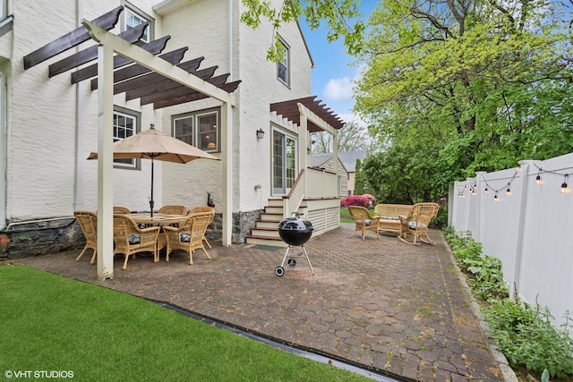 view of patio with a pergola, fence, and a deck