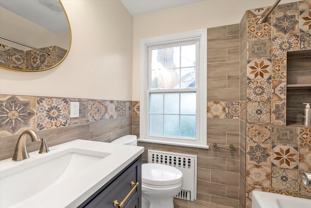 full bathroom featuring toilet, tile walls, radiator heating unit, and a wealth of natural light