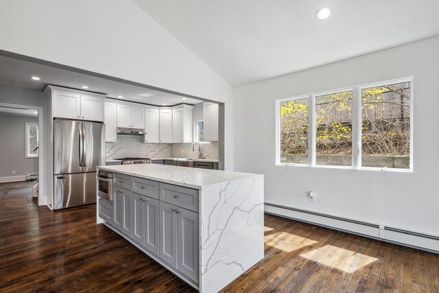 37 Soundview Rd, Huntington, NY 11743 - kitchen with appliances with stainless steel finishes, a baseboard radiator, dark wood-type flooring, light stone countertops, and tasteful backsplash