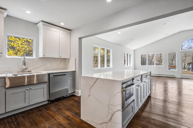 37 Soundview Rd, Huntington, NY 11743 - kitchen featuring stainless steel appliances, a baseboard heating unit, dark wood-style floors, tasteful backsplash, and light stone counters