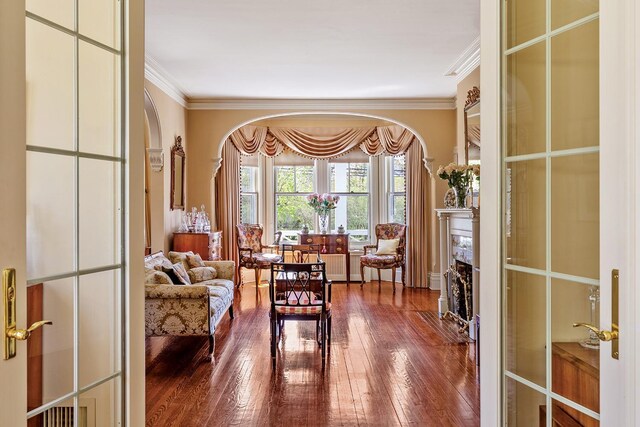 35 S Penataquit Ave, Bay Shore, NY 11706 - living area featuring arched walkways, ornamental molding, hardwood / wood-style floors, and a fireplace