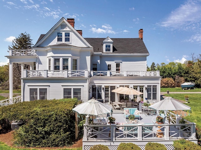 35 S Penataquit Ave, Bay Shore, NY 11706 - rear view of property featuring a balcony, a chimney, a patio, and outdoor dining space