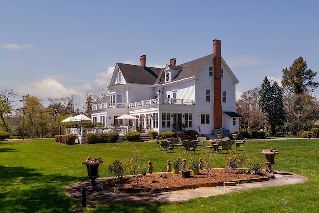 35 S Penataquit Ave, Bay Shore, NY 11706 - back of house featuring a balcony, a lawn, and a chimney