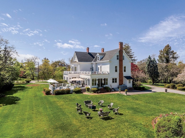 35 S Penataquit Ave, Bay Shore, NY 11706 - back of house with a balcony, a chimney, a yard, and a patio area