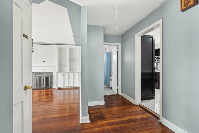 hall with baseboards and wood finished floors