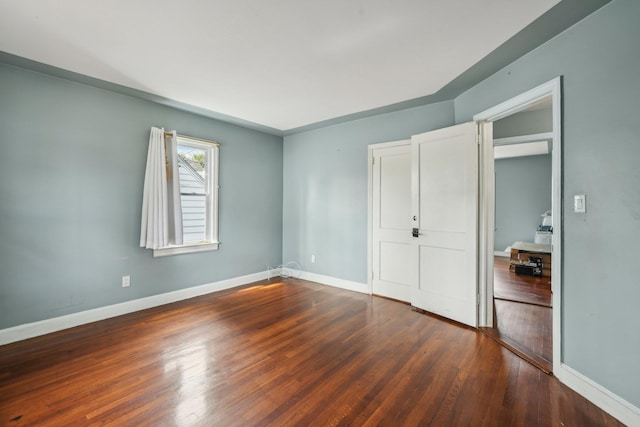 unfurnished bedroom with baseboards and wood finished floors