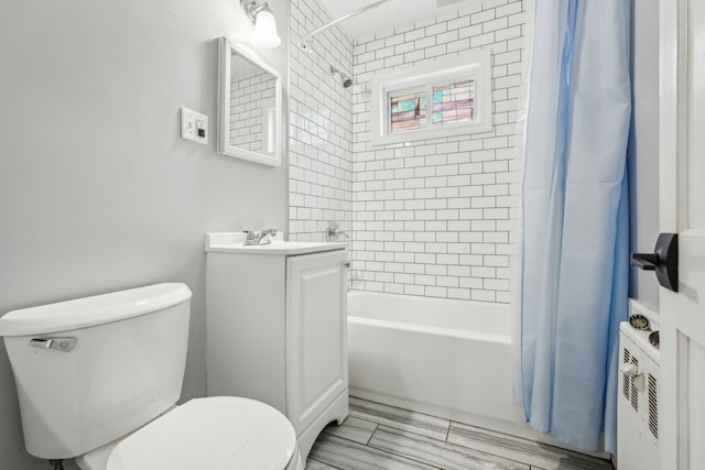 bathroom featuring toilet, shower / bathtub combination with curtain, and vanity