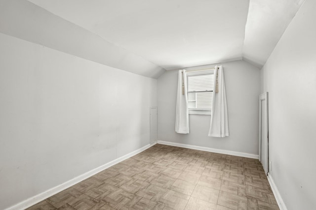 bonus room featuring baseboards and lofted ceiling