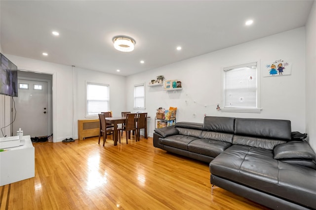 living room with light wood-style flooring, recessed lighting, and radiator