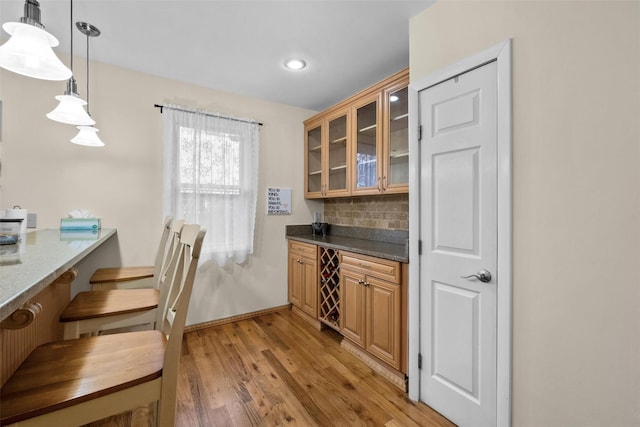 bar area featuring backsplash, light wood-type flooring, decorative light fixtures, recessed lighting, and baseboards