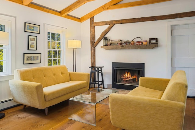 sitting room featuring lofted ceiling with beams, a lit fireplace, and hardwood / wood-style flooring