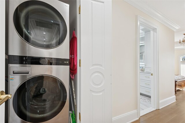 783 Oakleigh Rd, North Woodmere, NY 11581 - laundry area with wood finished floors, laundry area, baseboards, stacked washing maching and dryer, and crown molding