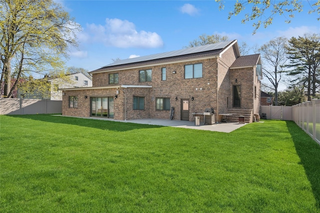 783 Oakleigh Rd, North Woodmere, NY 11581 - back of property with a patio, a fenced backyard, a lawn, brick siding, and solar panels