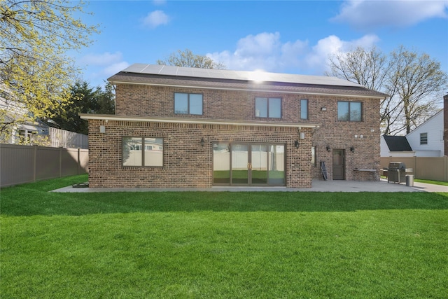 783 Oakleigh Rd, North Woodmere, NY 11581 - back of property with brick siding, roof mounted solar panels, a yard, and a patio area