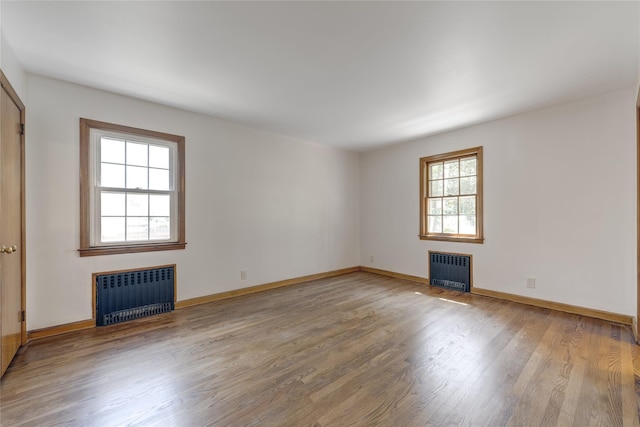 126 Bayville Ave, Bayville, NY 11709 - spare room featuring a fireplace, radiator, and wood finished floors