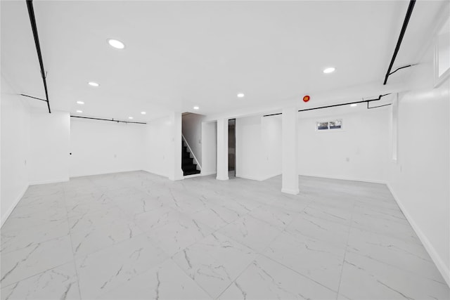 below grade area featuring marble finish floor, recessed lighting, baseboards, and stairway