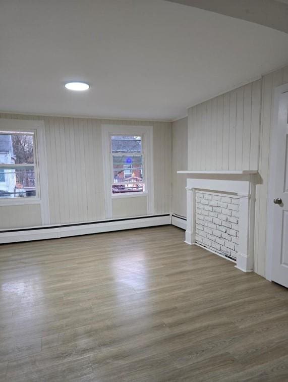 185 Mill St, Poughkeepsie, NY 12601 - unfurnished living room featuring a baseboard heating unit, healthy amount of natural light, and wood finished floors