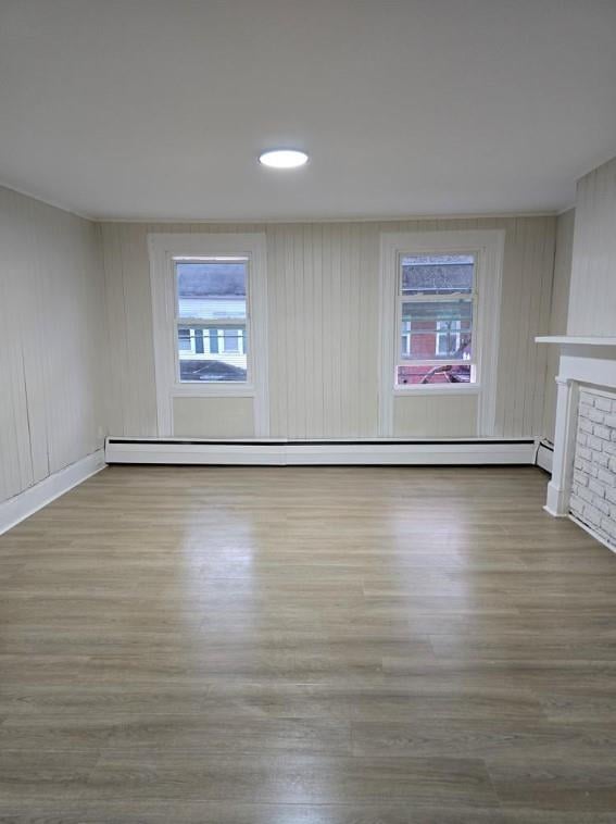 185 Mill St, Poughkeepsie, NY 12601 - spare room featuring wood finished floors, plenty of natural light, a fireplace, baseboard heating, and recessed lighting