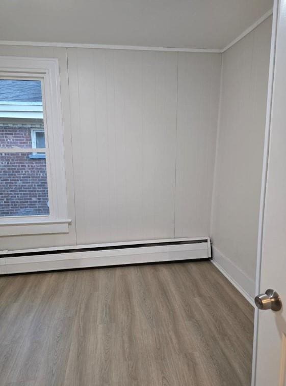 185 Mill St, Poughkeepsie, NY 12601 - spare room with baseboard heating, wood finished floors, and ornamental molding