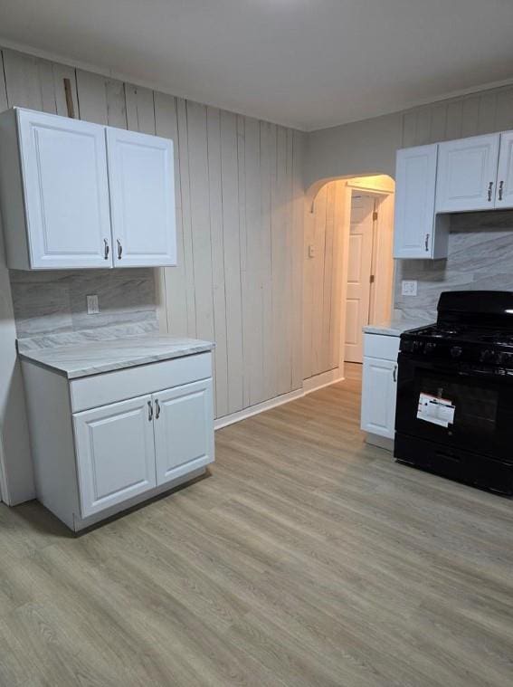 185 Mill St, Poughkeepsie, NY 12601 - kitchen with black range with gas cooktop, light countertops, white cabinetry, and light wood finished floors