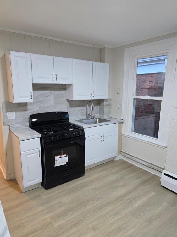 185 Mill St, Poughkeepsie, NY 12601 - kitchen with black range with gas stovetop, light wood-type flooring, white cabinetry, and light countertops