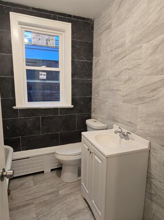 185 Mill St, Poughkeepsie, NY 12601 - bathroom featuring tile walls, vanity, and a baseboard heating unit