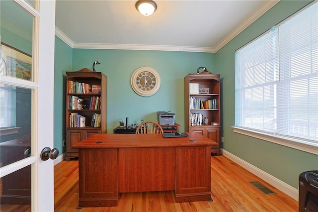 office featuring light wood finished floors, baseboards, visible vents, and ornamental molding