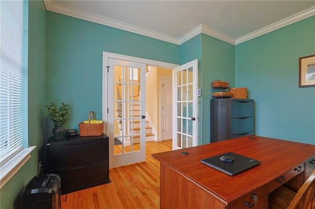 office space with light wood-style floors, french doors, and ornamental molding