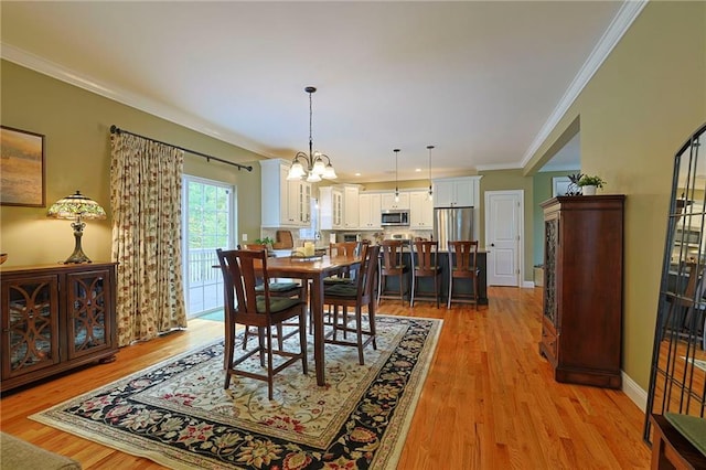 dining area featuring a chandelier, crown molding, and light wood-style flooring