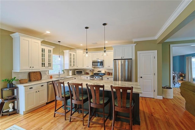 kitchen featuring glass insert cabinets, white cabinets, stainless steel appliances, and plenty of natural light