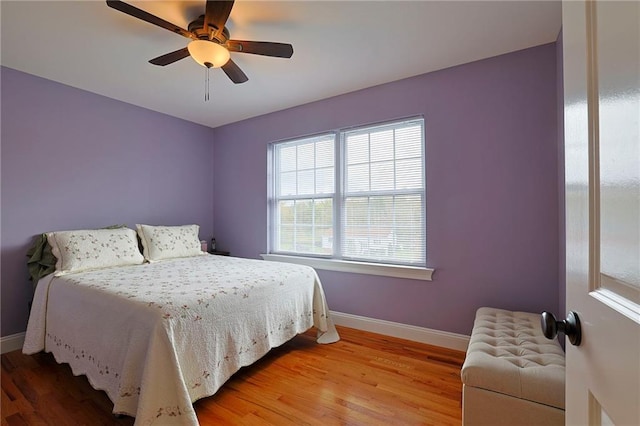 bedroom featuring light wood finished floors, baseboards, and a ceiling fan