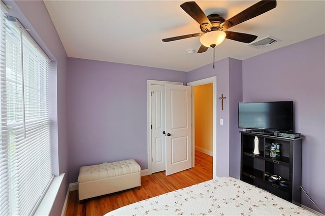 bedroom with ceiling fan, baseboards, wood finished floors, and visible vents