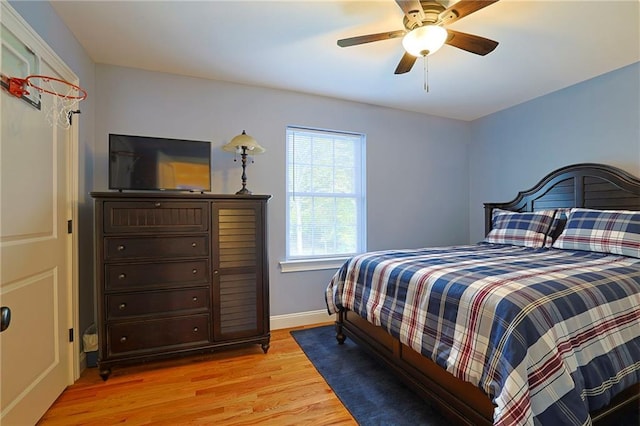bedroom featuring light wood-type flooring, a ceiling fan, and baseboards
