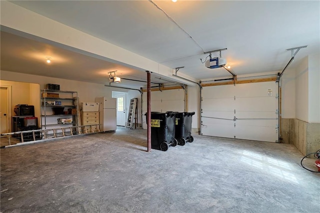 garage with a garage door opener and freestanding refrigerator
